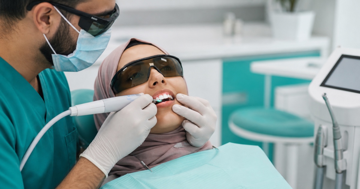 طبيب أسنان يستخدم ليزر الإربيوم للمساعدة على إزالة الفينير